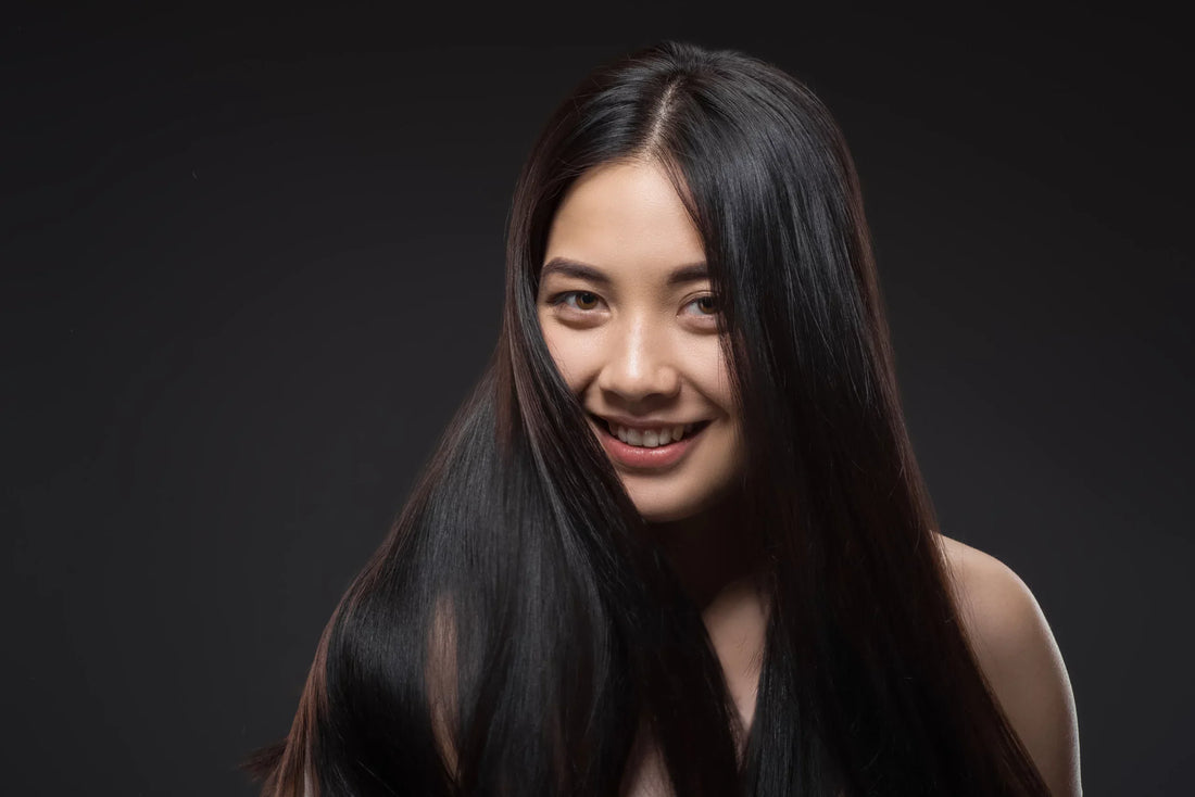 Mujer con melena negra brillante y uniforme, sin canas visibles, gracias al champú con color