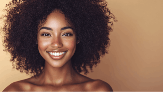 Mujer sonriente con rizos afro definidos e hidratados gracias al método curly